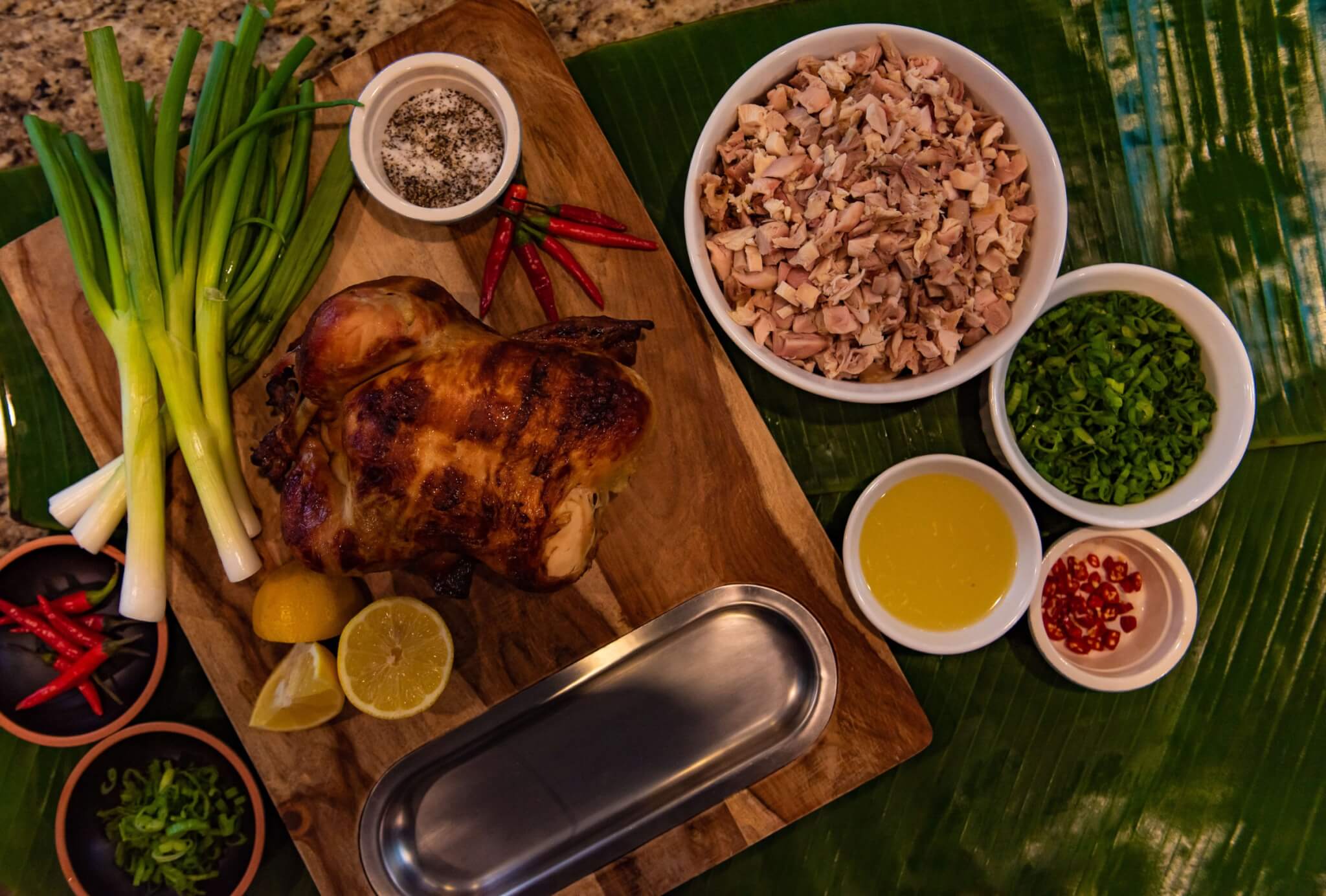 Chicken Kelaguen Recipe ingredients shown. Rotisserie Chicken, Green Onions, Lemon Juice, Thai Chiles, Salt and Pepper