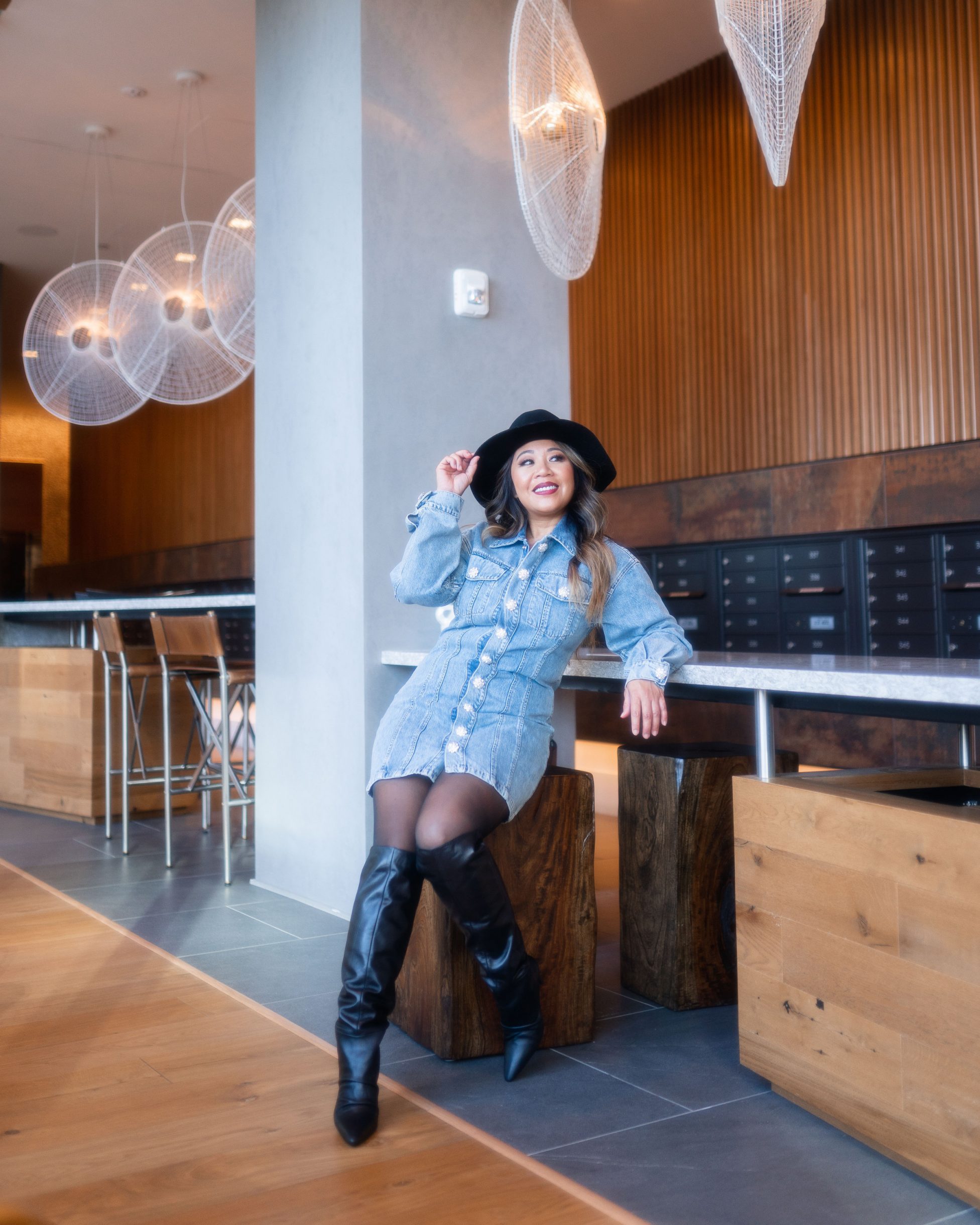 lady is sitting while wearing her denim dress
